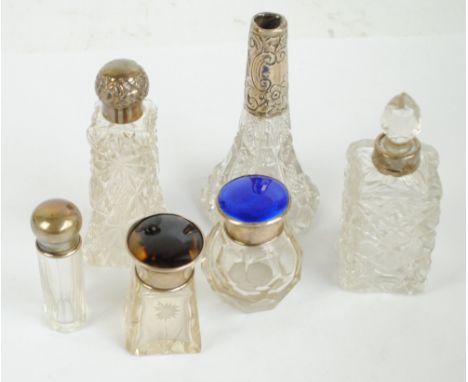 Six variously hallmarked silver topped clear cut glass scent bottles to include a blue guilloche enamel decorated example, H.