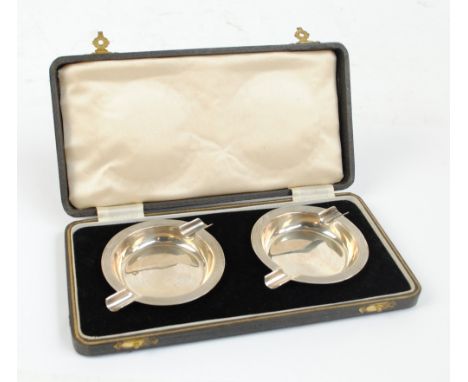 JOSEPH GLOSTER LTD; a cased pair of George VI hallmarked silver circular Art Deco style ashtrays with engine tuned decoration