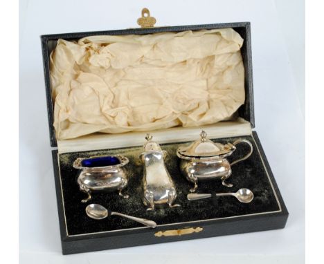 ADIE BROTHERS; a cased George V hallmarked silver cruet set comprising blue glass lined open salt, lidded mustard and pepper 