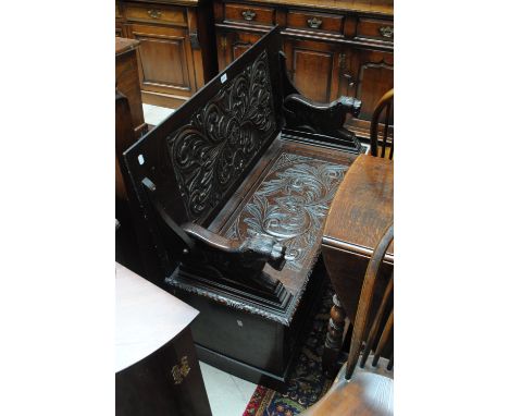 A late Victorian carved oak monk's bench with box seat and plinth base, width 108cm.