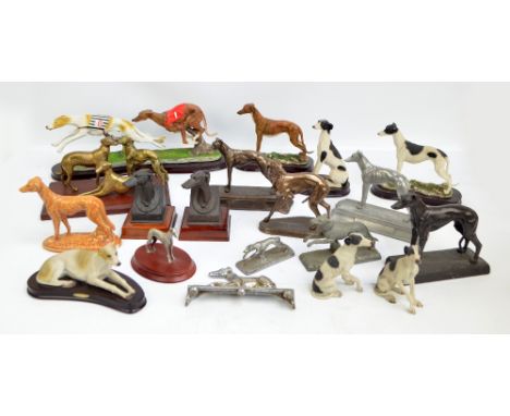 A large collection of greyhound models and figures including a silvered door stop in the form of a seated greyhound, a brass 