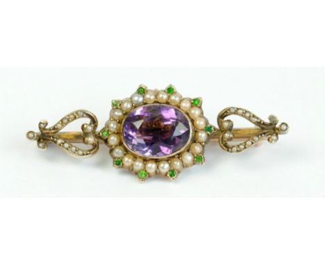 A 9ct rose gold Edwardian brooch in suffragette colours, the central faceted oval purple stone surrounded by half seed pearls