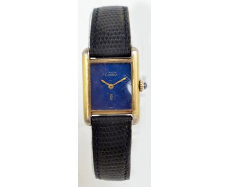 CARTIER; a lady's silver gilt Must de Cartier tank watch with blue cabochon winder on a Cartier leather strap, boxed.