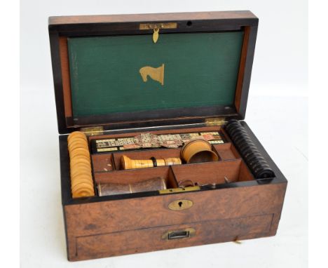 A 19th century burr walnut games box, the hinged lid centred with an oval vacant brass cartouche enclosing compartmentalised 