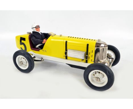 A good quality modern clockwork racing car and driver, modelled as a classic 1920s/30s sports car in yellow and black livery,