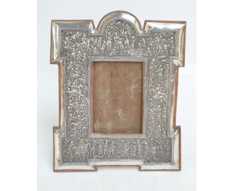 A large late 19th century Indian white metal photograph frame, impressed throughout with numerous figures and animals, with o