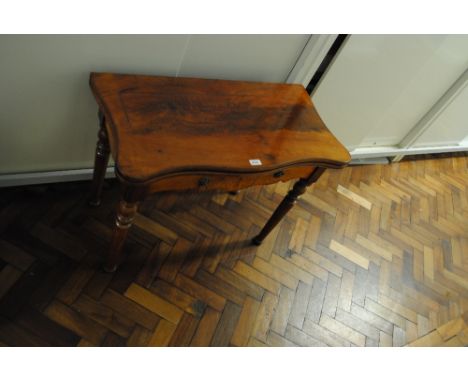 A reduced 19th century mahogany serpentine outline card table raised on turned legs.   CONDITION REPORT:  The top is split bo