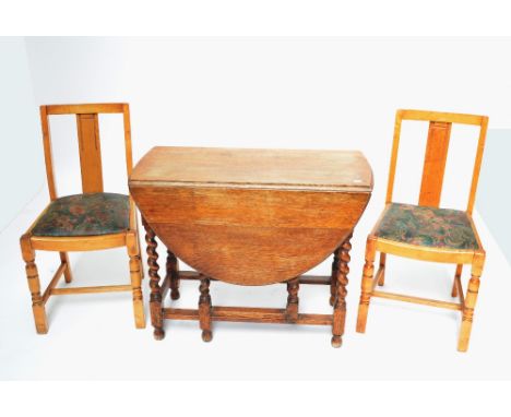 An early 20th century oak dropleaf table on stretchered barleytwist supports, height 72.5cm, and a set of four light oak kitc