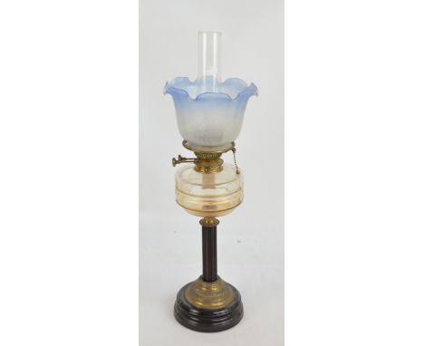 A late 19th century brass and wooden oil lamp with circular base, wooden fluted column and glass reservoir, the etched opaque