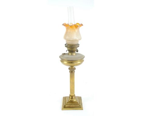 A Victorian brass oil lamp with fluted stem on stepped square base and associated orange and frosted glass tulip shaped shade