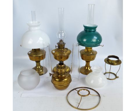 Three brass oil lamps, all with circular bases and brass reservoirs, with chimneys (one af) plus a further separate brass res