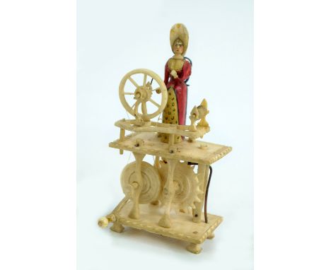 A prisoner of war carved bone automaton of a lady with a spinning wheel, height 11cm.