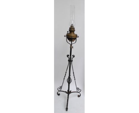 A late 19th/early 20th century wrought iron oil standard lamp with brass reservoir and floral motifs, height including glass 