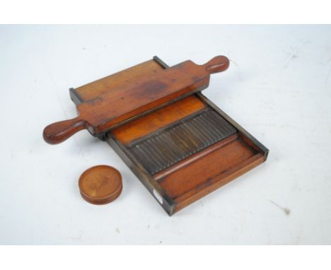 An early 20th century mahogany and brass mounted pill roller, 34 x 20.5cm.