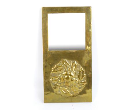 An Arts and Crafts brass wall mirror with square section plates above raised embossed stylised floral motif, 52.25 x 26.5cm. 