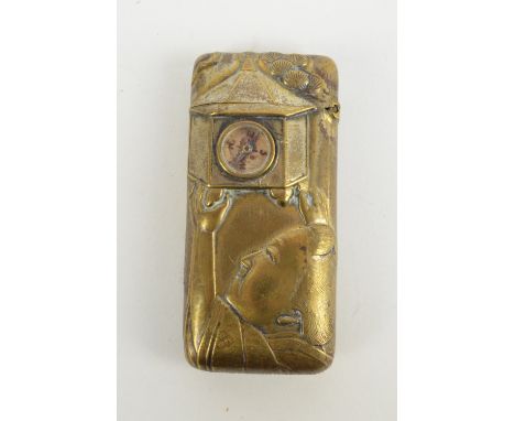 An unusual early 20th century brass vesta case embossed with Oriental figures, one holding a bird feeder set with compass, 7 