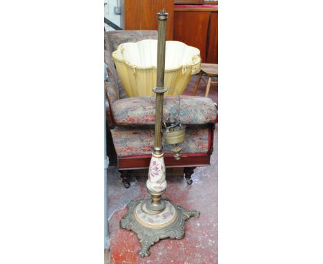 A decorative brass fluted standard lamp on ceramic floral painted baluster stem and similar spreading circular foliate scroll