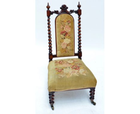 A Victorian walnut and tapestry upholstered nursing chair with padded back and seat, barleytwist uprights and turned front le