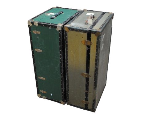 A green travelling trunk and a khaki travelling trunk both with reinforced edges, both with faded travel labels and both widt