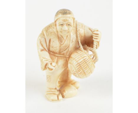 A Japanese Meiji period carved ivory netsuke of a man with basket, scratched character mark signature to base, height 5cm.