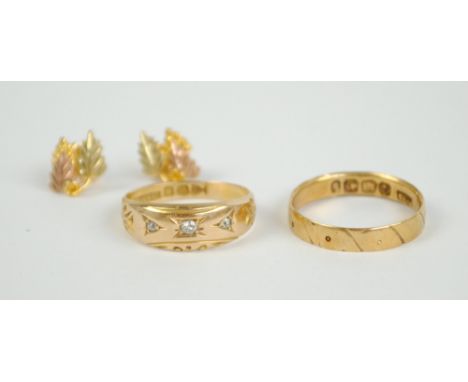 An 18ct gold ring set with three graduated diamonds, size K, an 18ct gold wedding band, size L, and a pair of Landstrom's thr