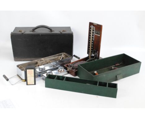 An early 20th century doctor's leather travelling case, part fitted including a round rectangular container with various tool