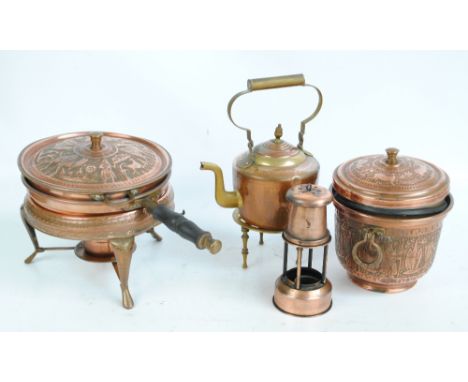 An Iranian copper chafing dish on tripod stand with burner, diameter 25cm, engraved and embossed with camels and figures to t