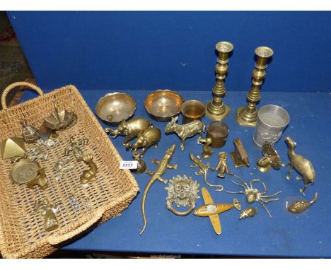 A shallow basket of brass animal and other ornaments,lion head door knocker, candlesticks with pushers etc.