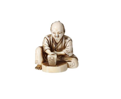 An ivory netsuke depicting a carpenter with a drawbar working on a wagon wheel. Japan, probably Edo.Provenance: 1) Paul Brand