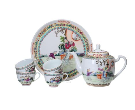 A six-piece polychrome porcelain tea set consisting of a teapot, four cups and a serving tray. Decorated with a garden scene 