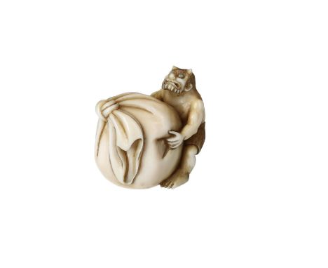 An ivory netsuke depicting an Oni pushing a bag forward with blue stone inlaid eyes. Signed Nanryo. Japan, Meiji.Provenance: 