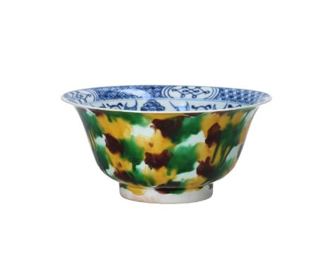 A 'spinach and egg' glazed porcelain bowl, with a blue and white interior in a floral decoration. China, Kangxi. H. 8.5 cm. D