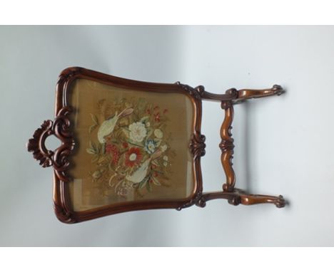 A 19TH CENTURY FANCY MAHOGANY FRAMED FIRESCREEN with insert woolwork panel depicting two doves amongst flora, supported on fo