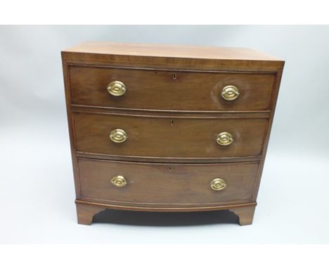 A 19TH CENTURY MAHOGANY BOW FRONTED SMALL SIZED CHEST with crossbanded top, three graduating plain front drawers supported on