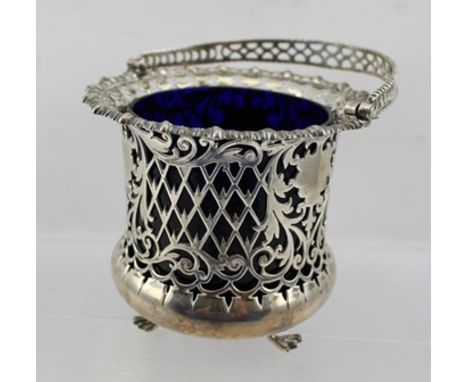 JAMES DIXON & SONS LTD. AN EDWARDIAN SILVER SUGAR BASKET with blue glass liner, having pierced decoration, with swing handle,
