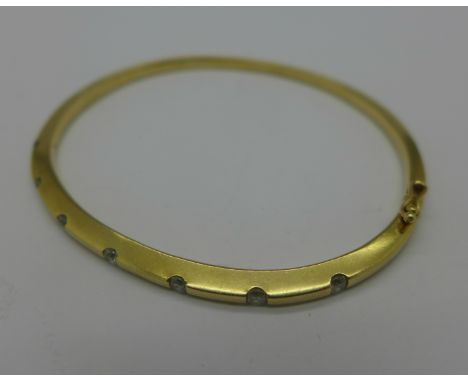 A solid 9ct gold bangle set with seven diamonds, 15.1g