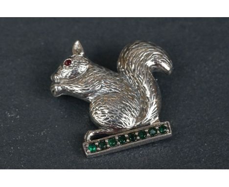 Silver squirrel brooch sat on emerald style platform 