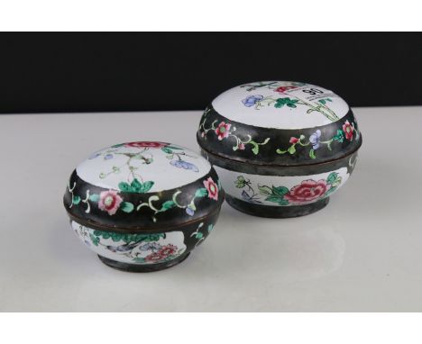 Pair of Chinese Enamel Circular Lidded Boxes decorated with panels of flowers on a black ground, largest 12cms diameter 