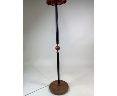 A vintage 1960s standard lamp, circular base, black painted wood columns, brassware with circular wooden feature.H:145cm