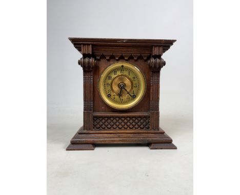 A late 19th early 20th Century stained oak cased American shelf clock with decorative dial, bezel and Ansonia gong striking m