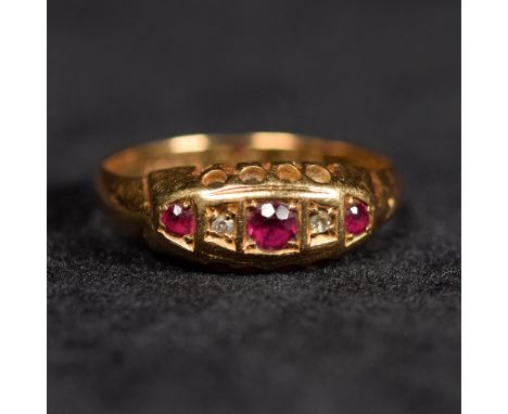 An 18ct gold three stone ruby ring with single cut diamond accents. 2.6g. Size Q.