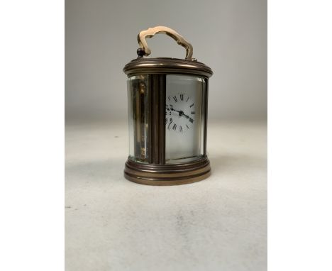 A miniature French gilt brass five glass oval carriage clock. Movement stamped made in France, 11 jewel movement. With key. H