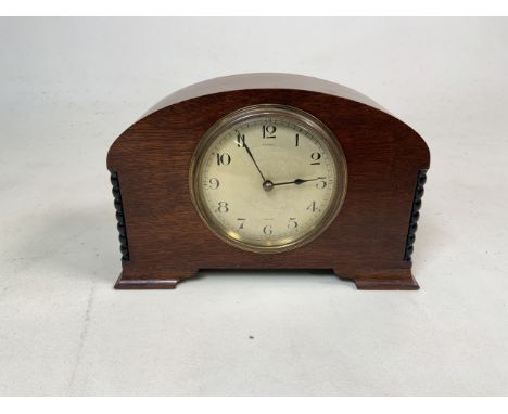 An Edwardian mahogany mantle clock engine turned face with arabic markers marked Peace, Leeds, French Movt. Inscribed on bott