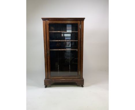 A late 19th early 20th century rosewood inlaid music cabinet with brass gallery to top, large glazed door and ceramic castors