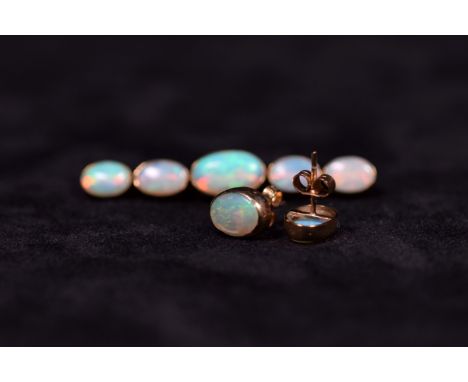 A suite of opal jewellery to include a pair of oval 9ct set earstuds together with a graduated five stone 9ct mounted opal br