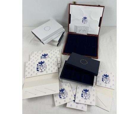 A box of assorted modern collectable coin boxes and envelopes. 