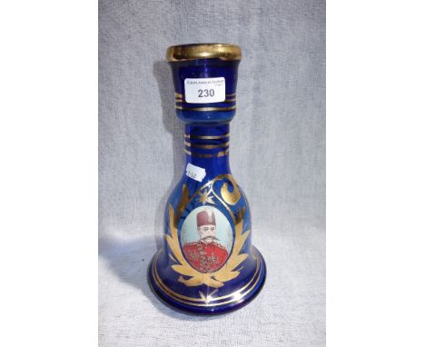 A CONTINENTAL BLUE GLASS CARAFE, with a portrait of an officer surrounded by gilt decoration, 28 cm high