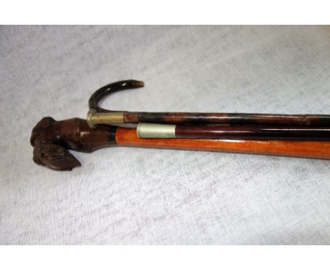 A WALKING STICK , carved with a dog's head, a swagger stick and similar items