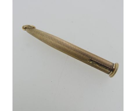 A 9ct gold Cigar Piercer, of traditional bullet form with engine turned decoration, gross total weight 10.2g. . 