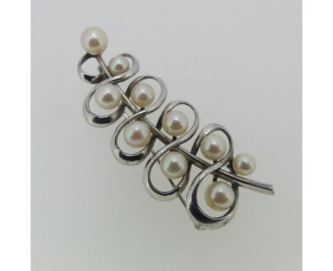 Mikimoto; A cultured pearl Brooch, of abstract leaf design set with ten variously sized circular cultured pearls, all mounted